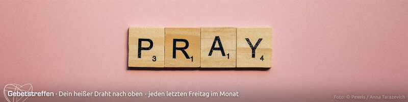 Webbanner "Gebetstreffen": Hölzerne Scrabble-Steine, zusammengesetzt zum englischen Wort "Pray" auf neutral-hellrosa Fläche