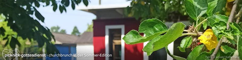Banner "Picknick-Gottesdienste": Privates Foto von Kathis Laube, rot gestrichene Holzlaube unscharf im Hintergrund, davor scharf im Vordergrund die saftig grünen Blätter eines Apfelbaums